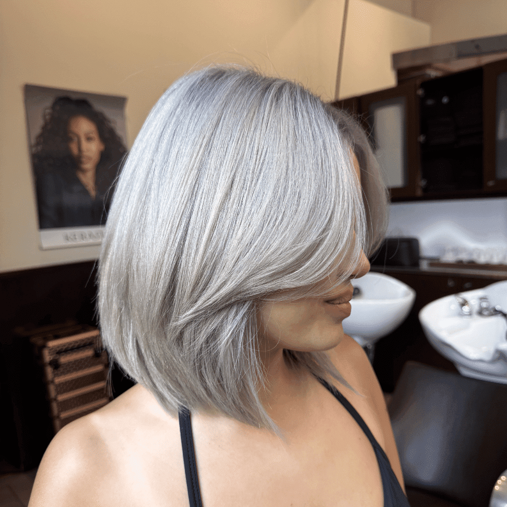 Bob hairstyle with silver-grey color in a modern salon setting.