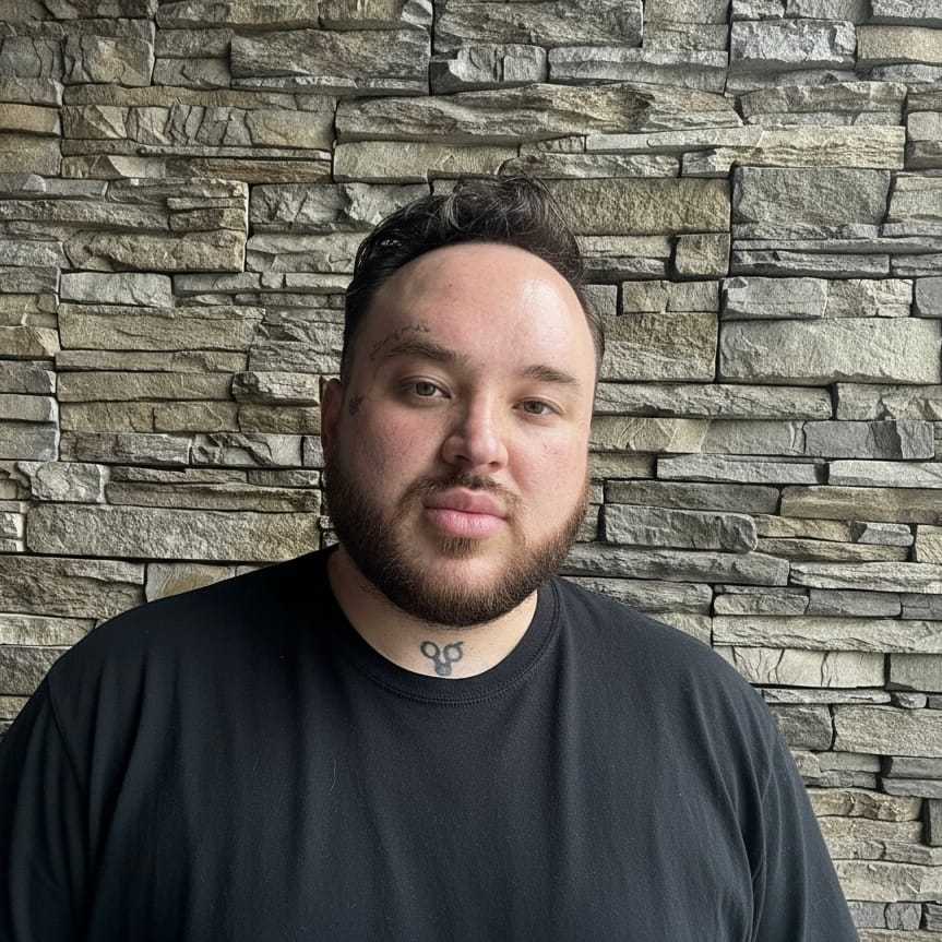 Portrait of Zachary Mosco, a professional stylist at Enmoda Salon x Spa, showcasing their expertise and style.