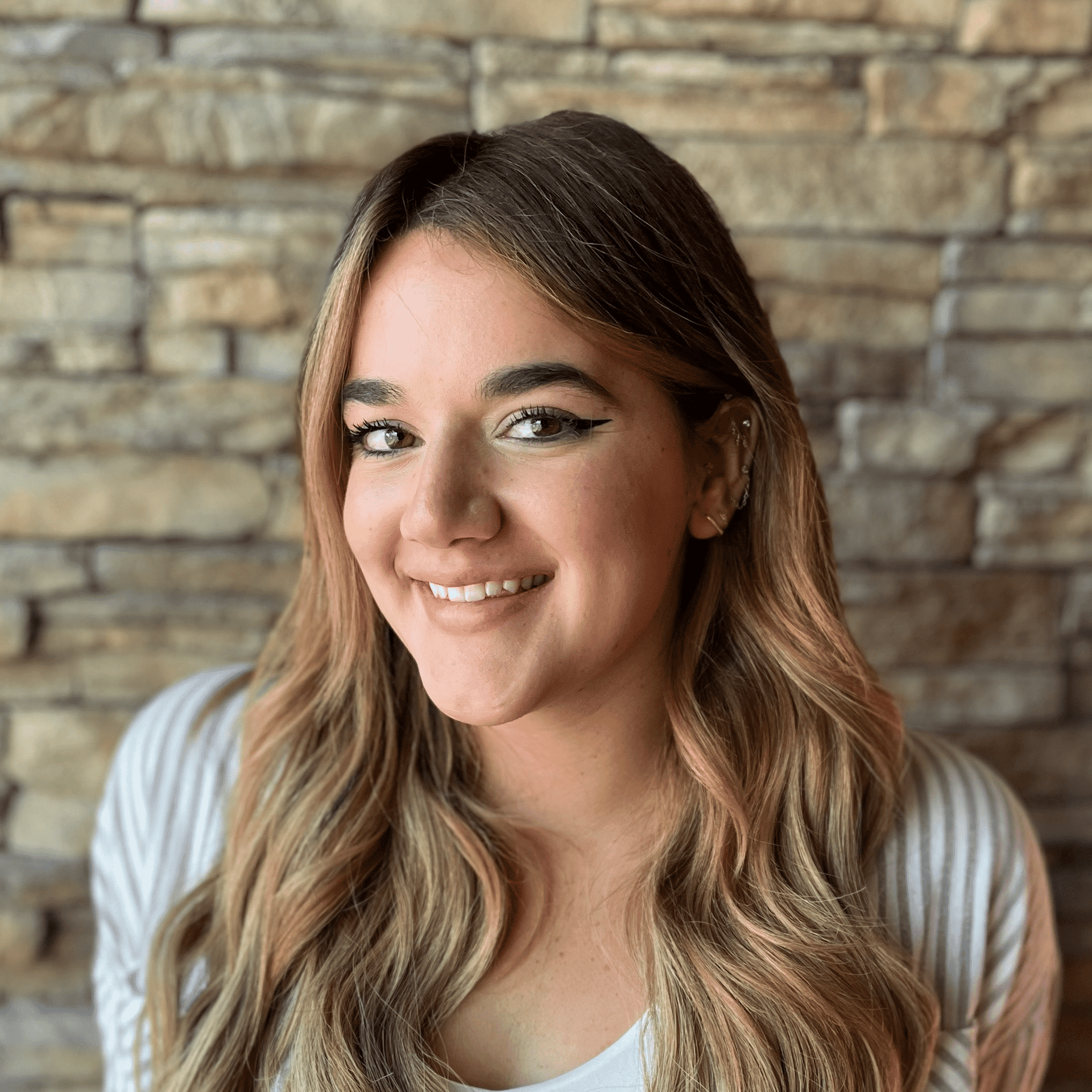 Portrait of Camryn Pagan, a professional stylist at Enmoda Salon x Spa, showcasing their expertise and style.