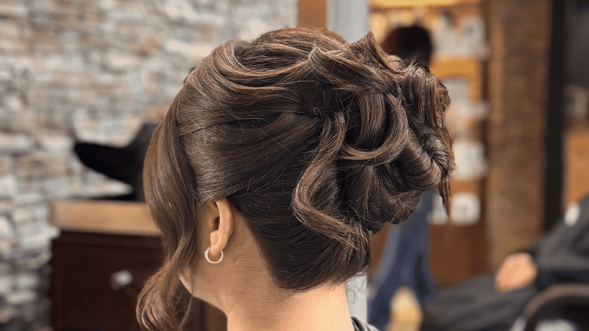 Elegant updo hairstyle with curls viewed from behind.