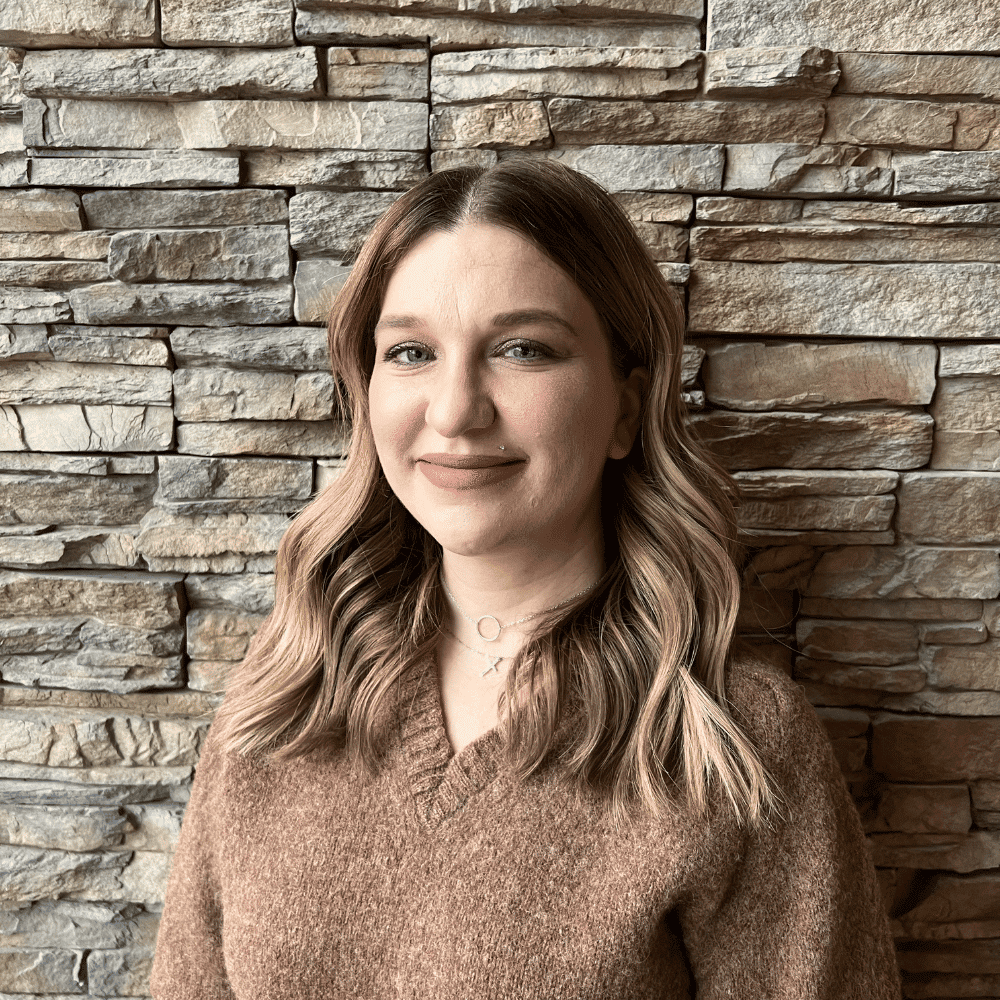 Portrait of Camrin Dekis, a professional stylist at Enmoda Salon x Spa, showcasing their expertise and style.