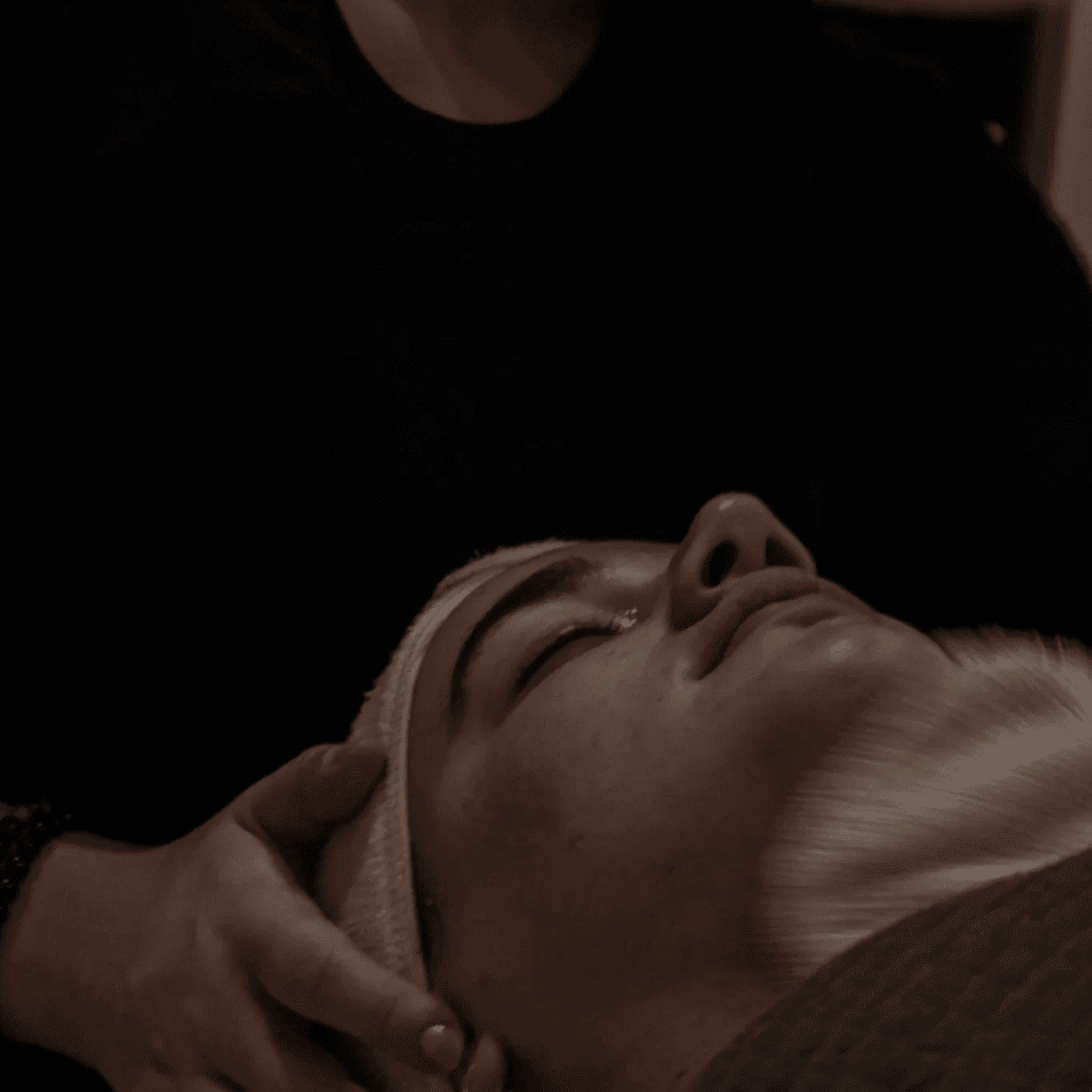 Facial treatment being performed on a relaxed client at a spa.