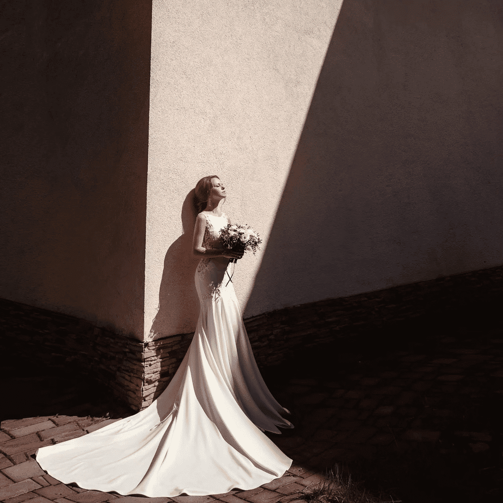 Bridal portrait with long shadow against a textured wall.